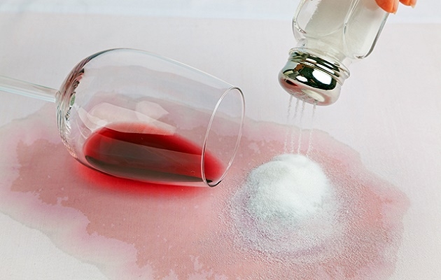 Salt being used to clean a red wine spillage